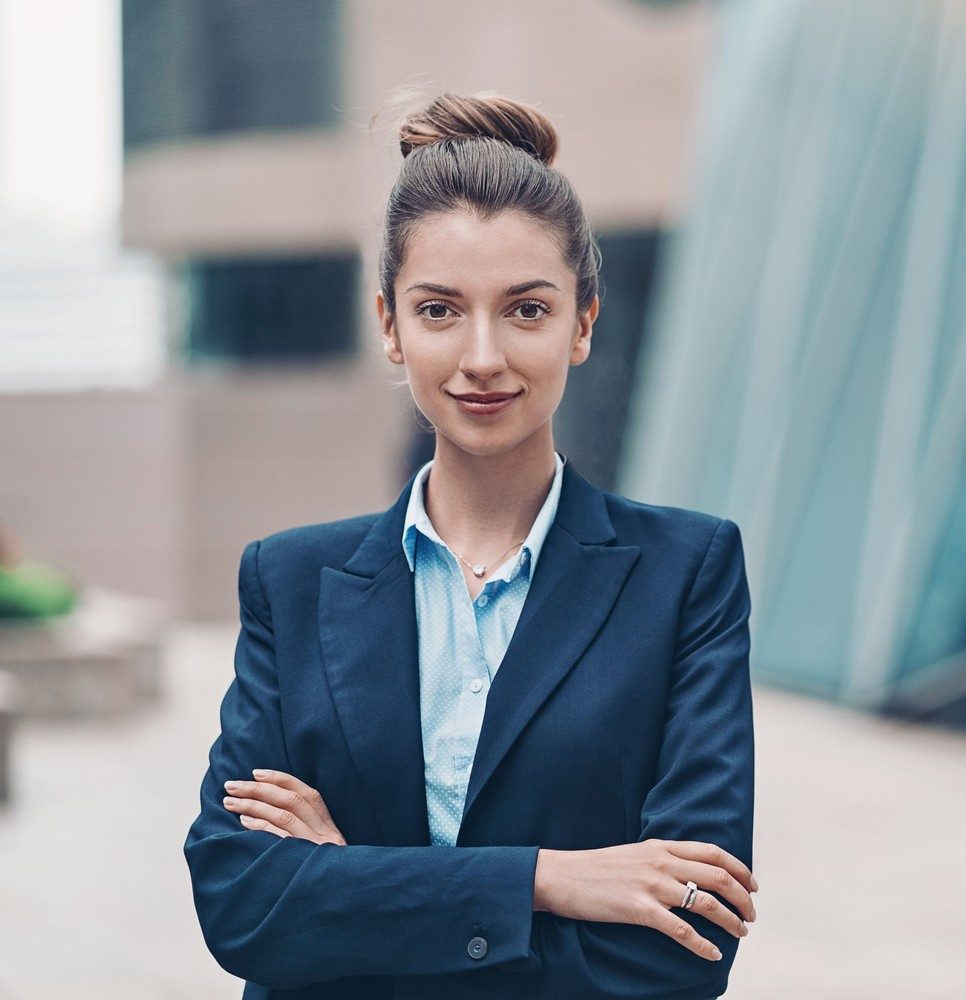 Portrait of a smiling businesswoman standing with arms crossed