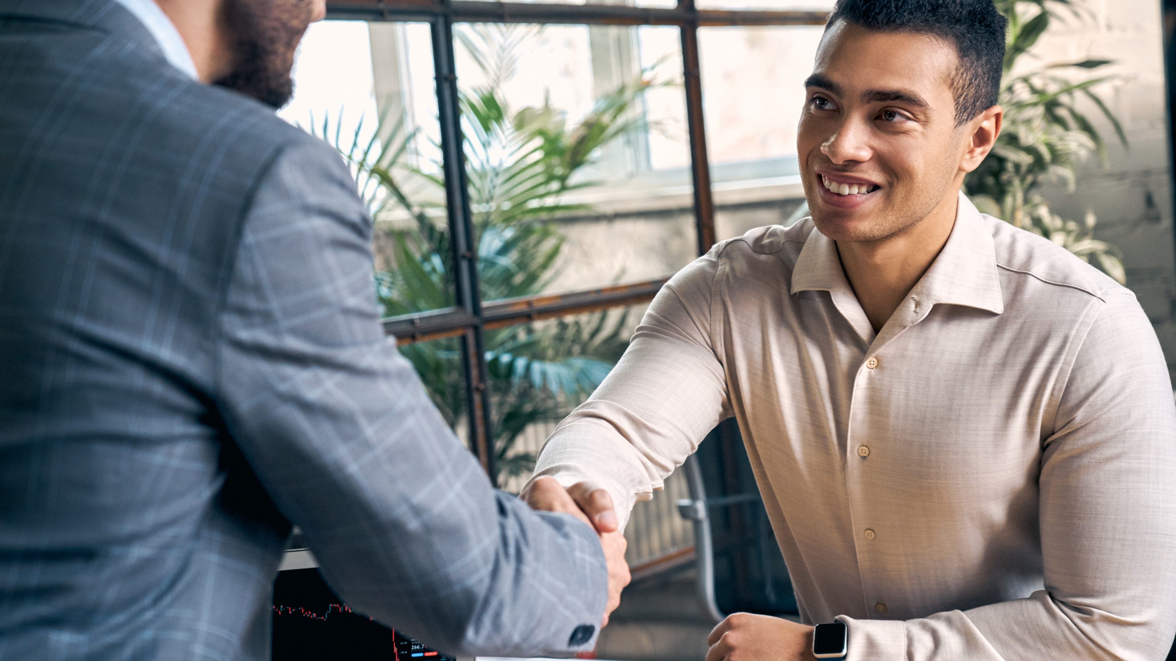 Confident businessman in formal wear making handshake gesture with new employee after interview. Two man making deal in office