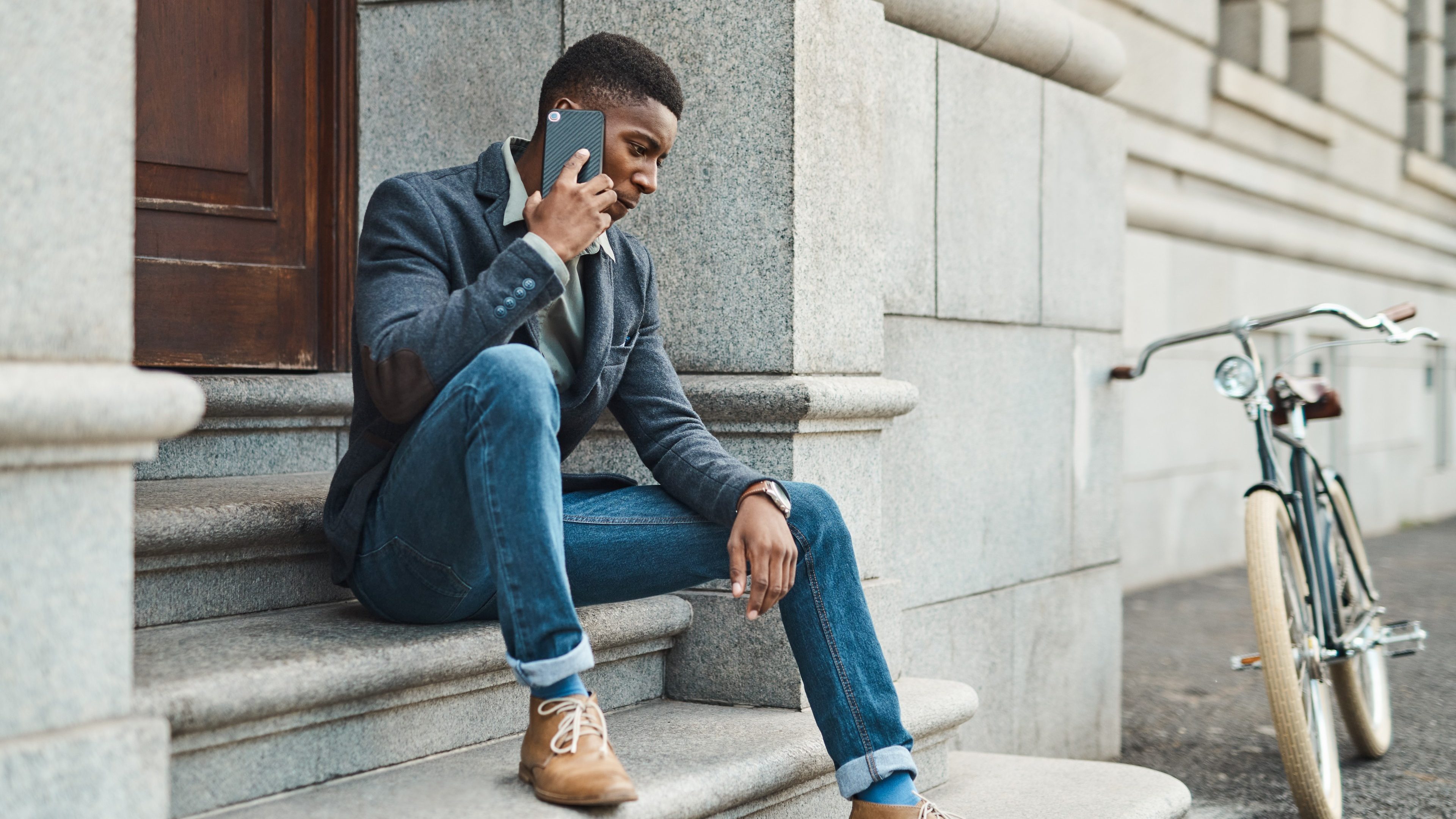 Shot of a young businessman using a smartphone against an urban background